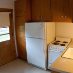 Kitchen with fridge, stove, and sink with back door